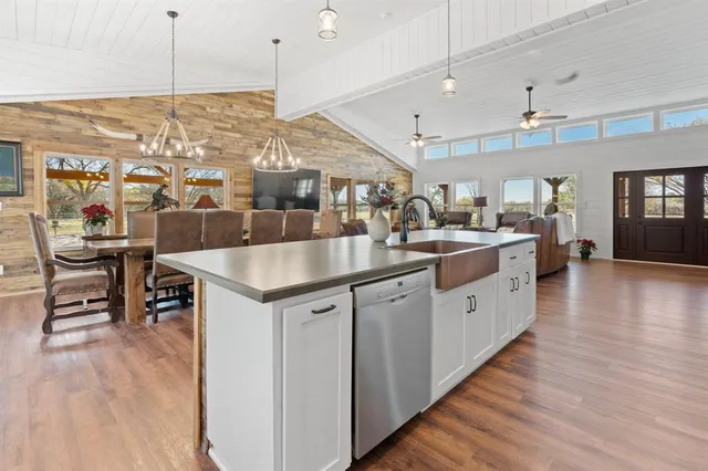 a kitchen with stainless steel appliances kitchen island granite countertop a stove and a wooden floors