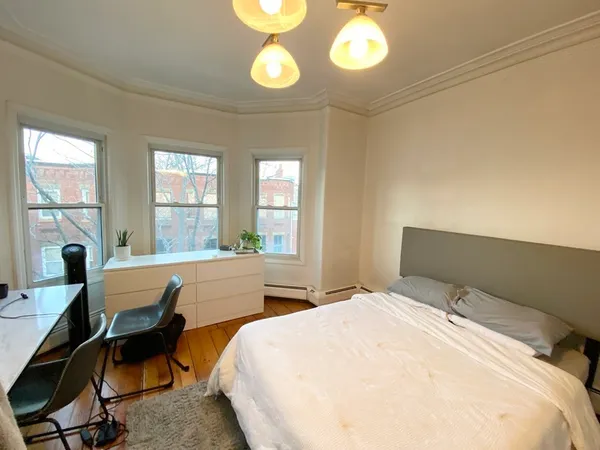 a bedroom with a bed and a large window