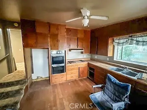a kitchen with a sink appliances cabinets and a counter top space