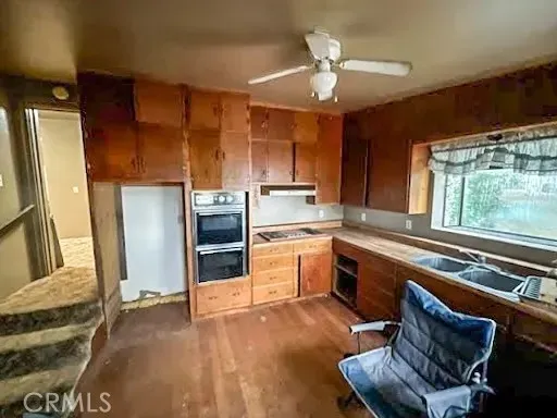 a kitchen with a sink appliances cabinets and a counter top space