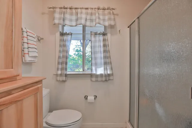 a bathroom with a granite countertop shower a toilet and a sink