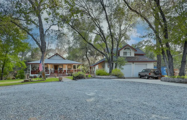 a front view of a house with a yard and trees