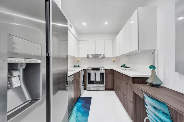 a kitchen with stainless steel appliances white cabinets and a refrigerator