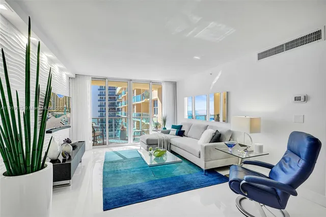 a living room with furniture fireplace and a large window