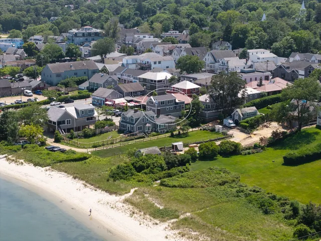 an aerial view of residential houses with outdoor space and trees