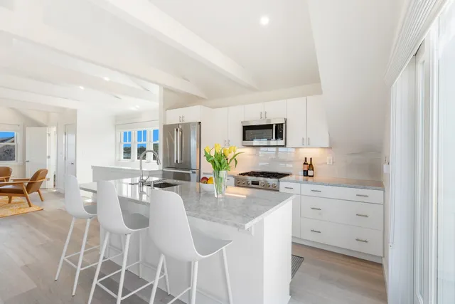 a kitchen with white cabinets and appliances