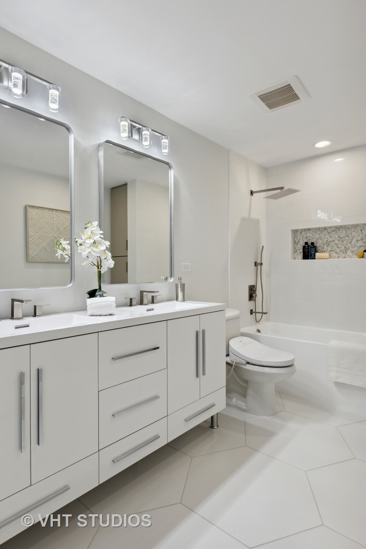 17 North Loomis Street, Unit 1J Chicago, IL 60607 - Photo 15 of 30 a bathroom with a double vanity sink a toilet and a mirror