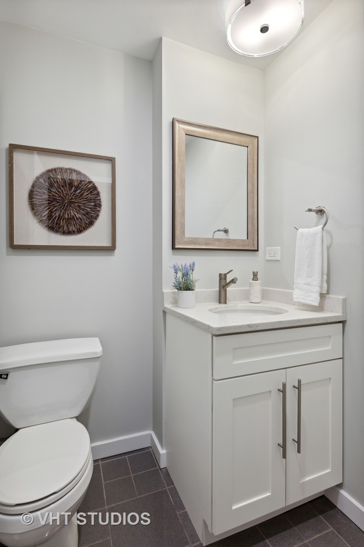 17 North Loomis Street, Unit 1J Chicago, IL 60607 - Photo 17 of 30 a bathroom with a toilet a sink and mirror