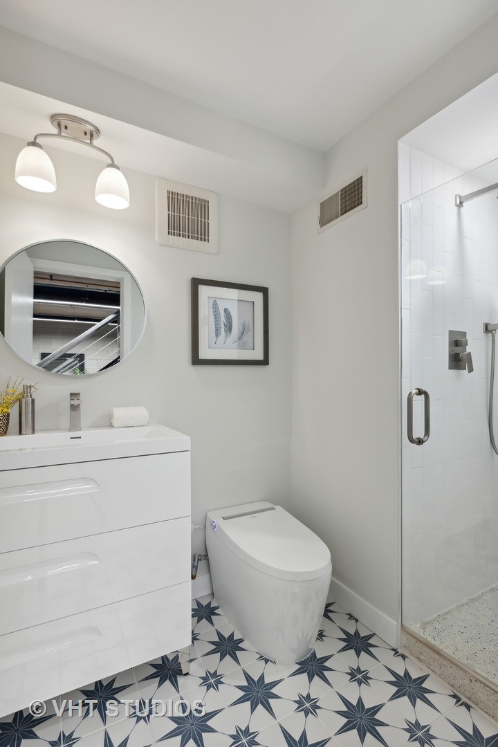 17 North Loomis Street, Unit 1J Chicago, IL 60607 - Photo 21 of 30 a bathroom with a toilet a sink and shower