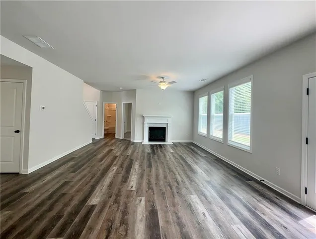 a view of empty room with wooden floor and fireplace