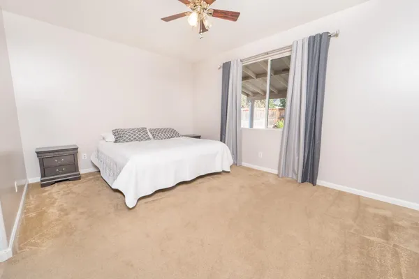 a bedroom with a bed and a ceiling fan