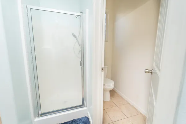 a bathroom with a granite countertop shower and a toilet