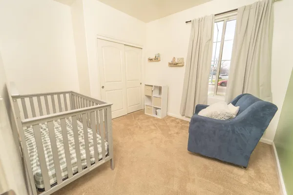 a living room with furniture and a baby crib