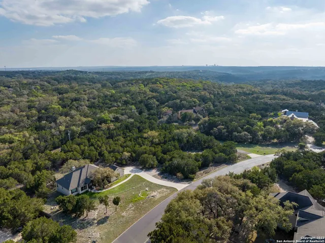 an aerial view of house with yard and mountain view in back