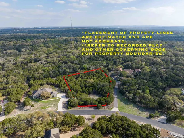 a green field with lots of trees in the background