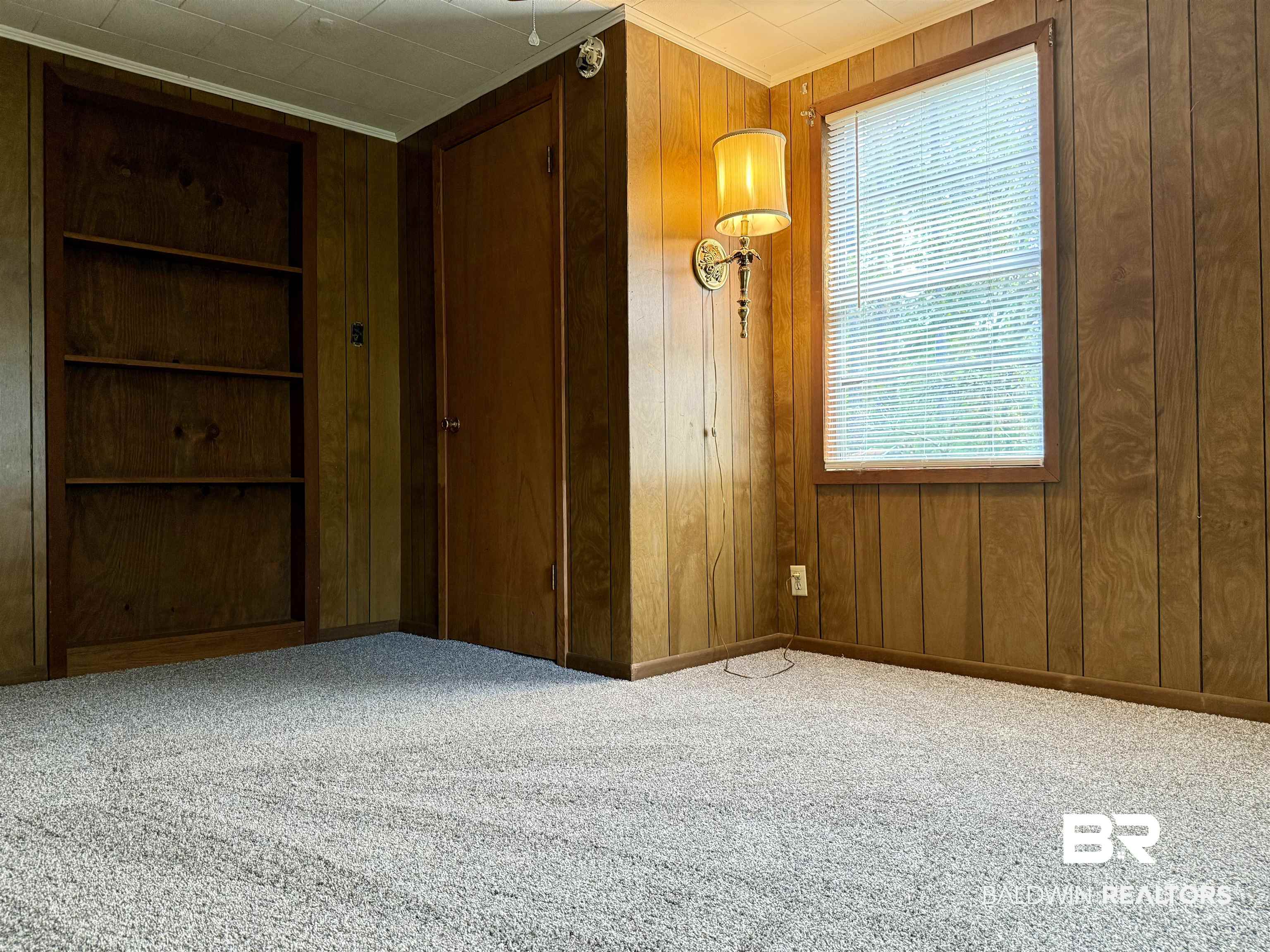 826 West Side Road Castleberry, AL 36432 - Photo 26 of 34 Spare room featuring light carpet, wood walls, and crown molding