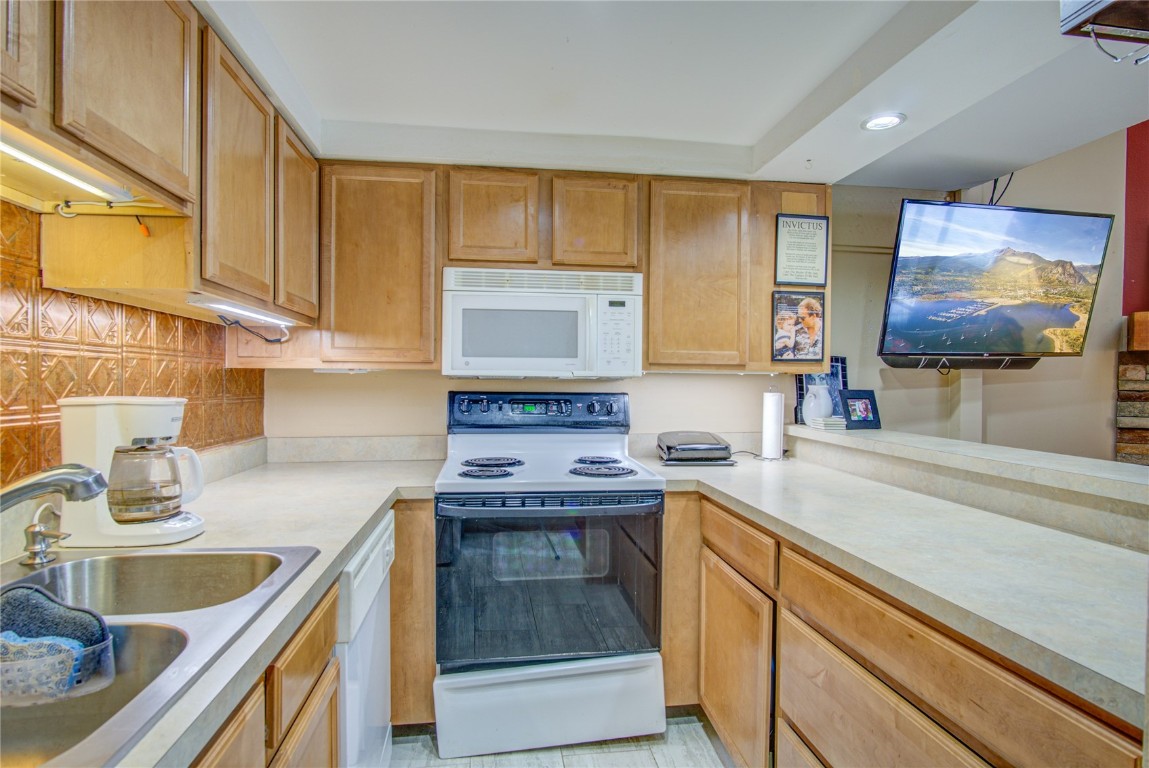 78 Guller Road, Unit 104 Copper Mountain, CO 80443 - Photo 6 of 15 a kitchen with stainless steel appliances granite countertop a sink and a microwave