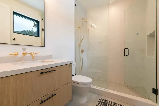 a bathroom with a sink a toilet and shower