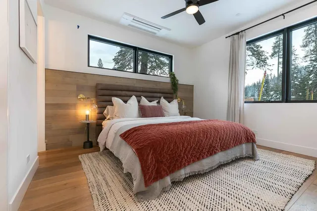 a bedroom with a bed and large windows