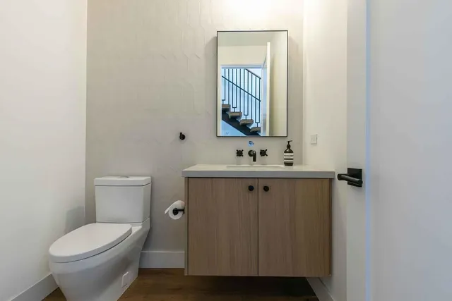 a bathroom with a toilet sink and mirror