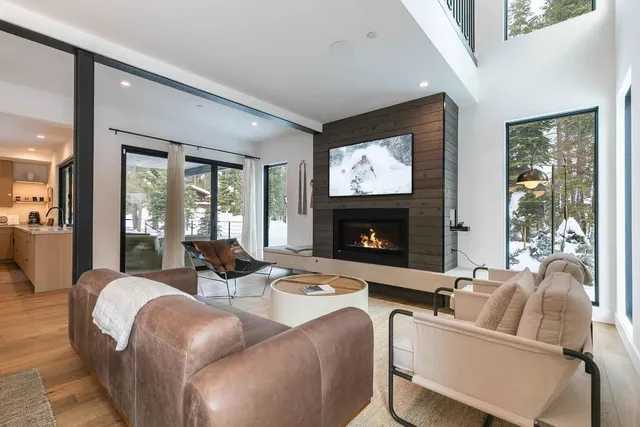 a living room with furniture a large window and a fireplace