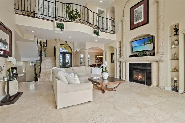 a living room with furniture large windows and wooden floor