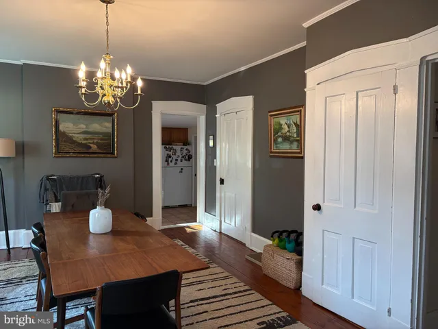 a view of a dining room with furniture a chandelier and wooden floor
