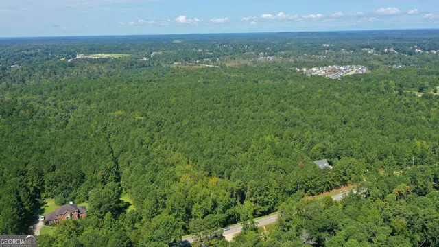 an aerial view of residential houses with outdoor space and trees