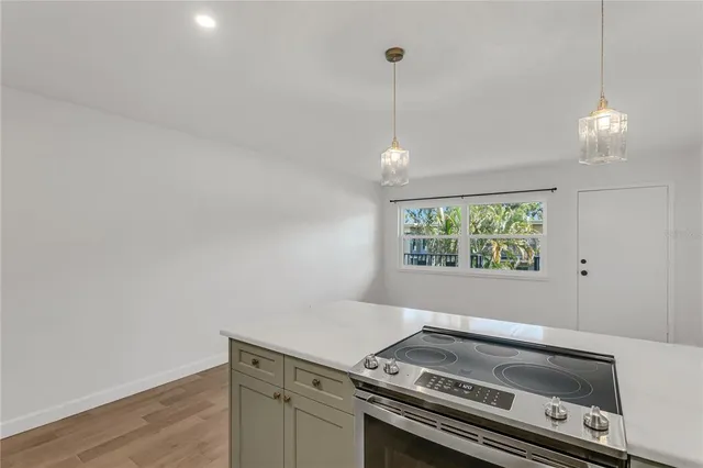 a view of kitchen with a stove wooden floor and window