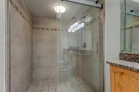 a bathroom with a granite countertop toilet sink and mirror