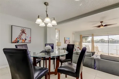 a dining room with furniture a large window and a chandelier