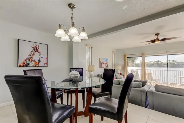 a dining room with furniture a large window and a chandelier