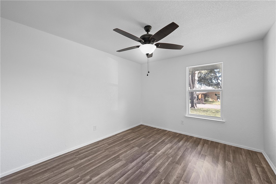 337 Travis Lane Hewitt, TX 76643 - Photo 11 of 22 a view of an empty room with wooden floor and a window