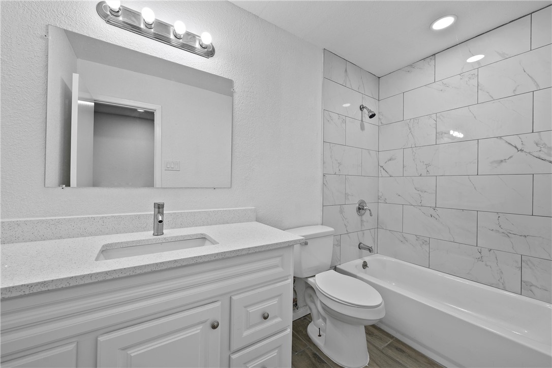 337 Travis Lane Hewitt, TX 76643 - Photo 13 of 22 a bathroom with a toilet a sink a mirror and bathtub