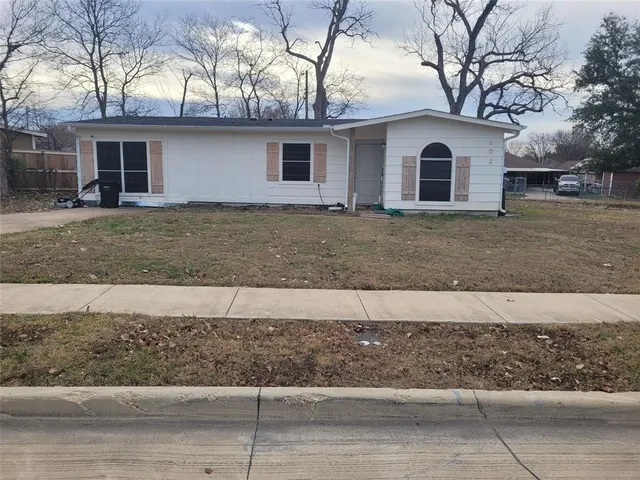 a view of a white house with a yard and large tree