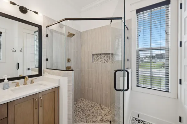 a en suite bathroom with a double vanity sink and a mirror