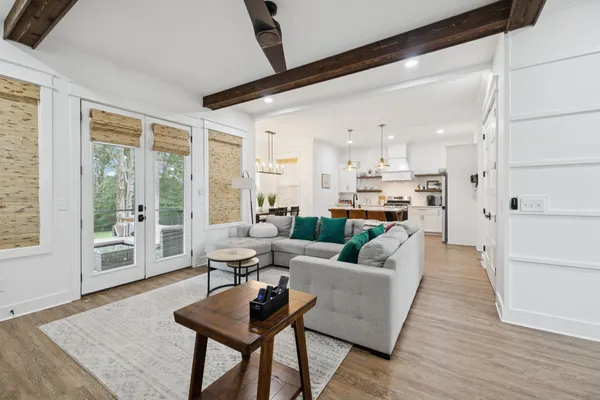 a open kitchen with stainless steel appliances granite countertop a stove a refrigerator a kitchen island a dining table and chairs with wooden floor