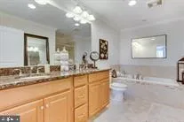 a bathroom with double vanity sinks a vanity a lamp and a mirror