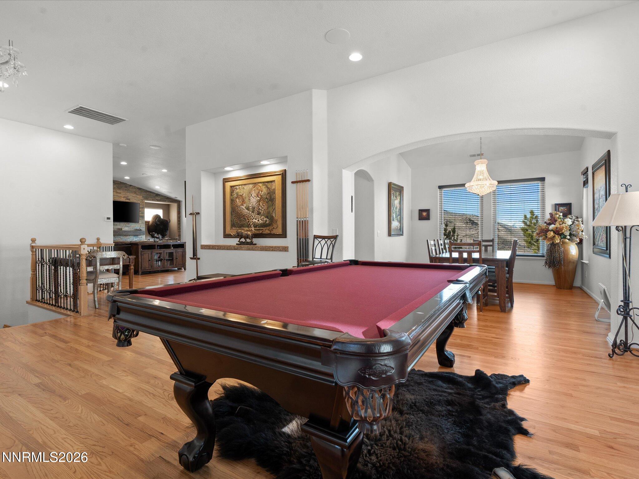 a room with pool table and wooden floor