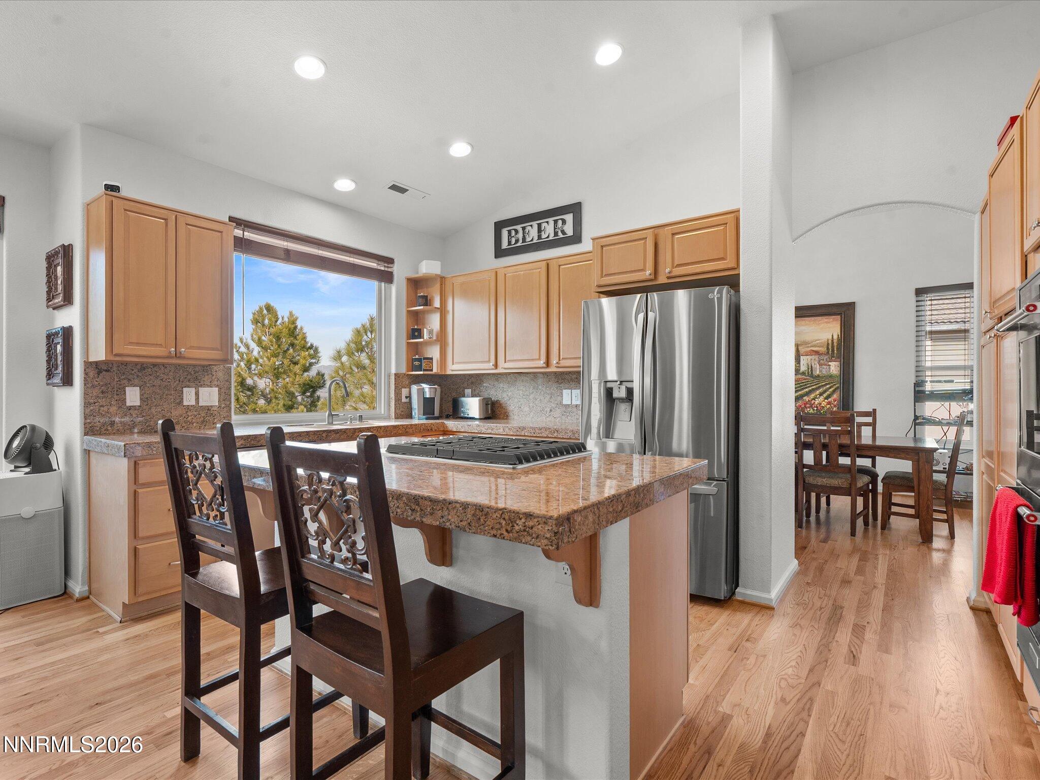 4943 Foxcreek Trail Reno, NV 89519 - Photo 5 of 26 a kitchen with stainless steel appliances granite countertop table chairs and wooden floor