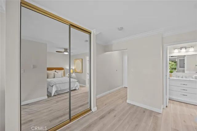 a view of a hallway with bathroom and wooden floor