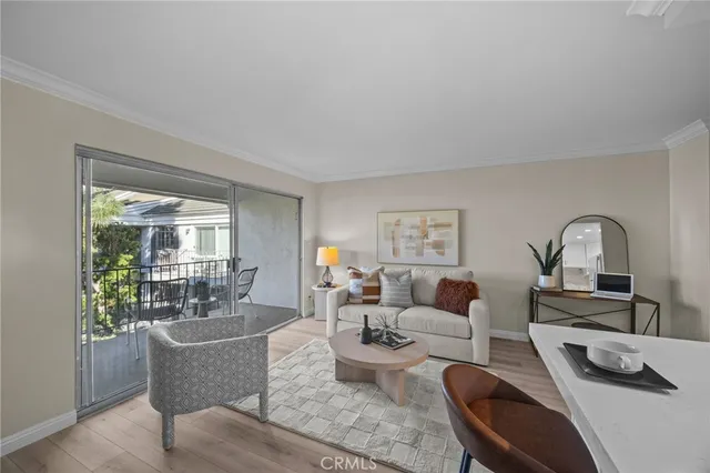a living room with furniture a large window and wooden floor