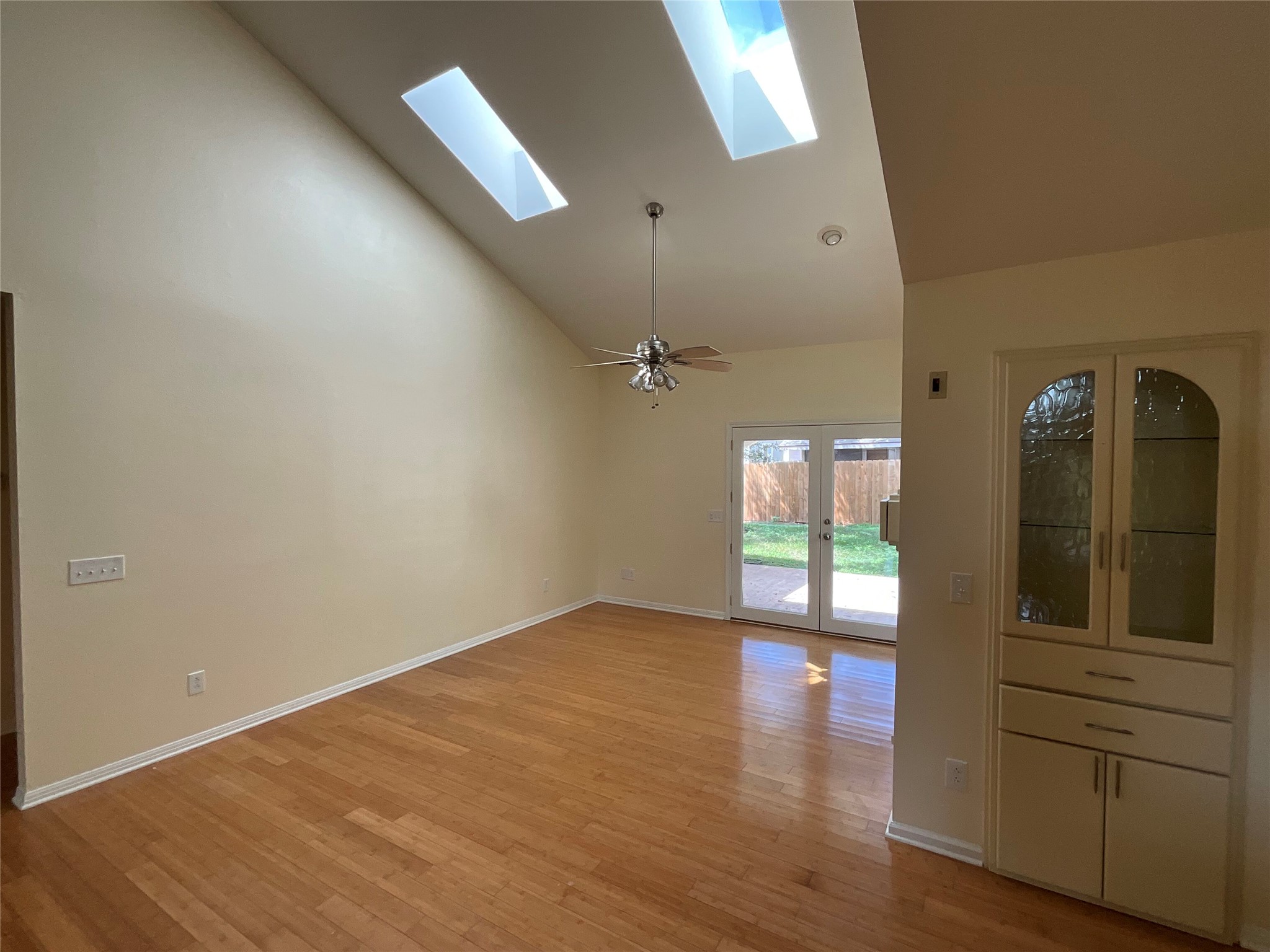 15702 Racine Cove Austin, TX 78717 - Photo 14 of 27 Natural illumination highlights the gleaming hardwood floors and vaulted ceilings, leading to a private outdoor space.
