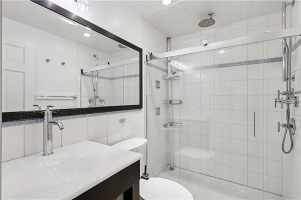 a bathroom with a sink a toilet and shower