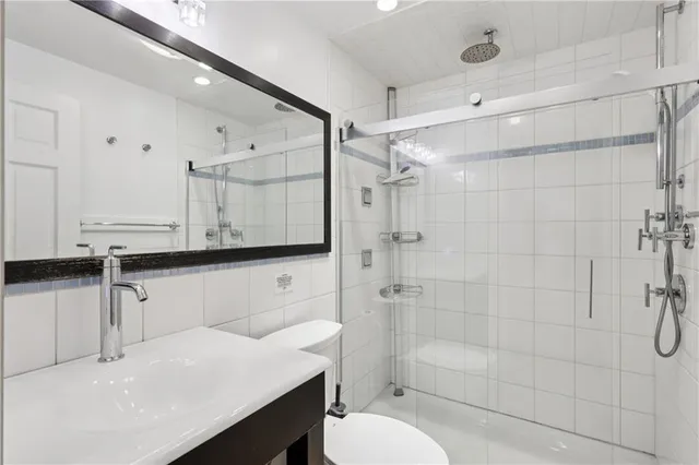 a bathroom with a sink a toilet and shower