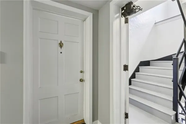 a view of staircase with white walls and white door