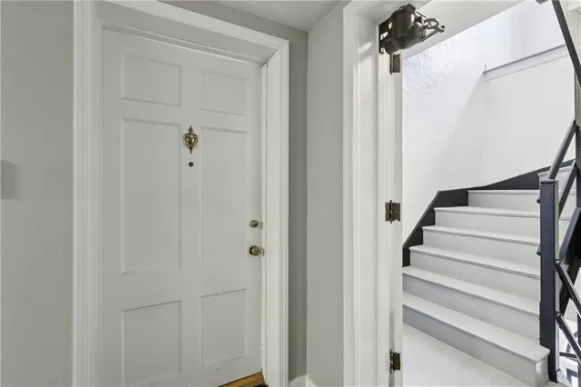 a view of staircase with white walls and white door