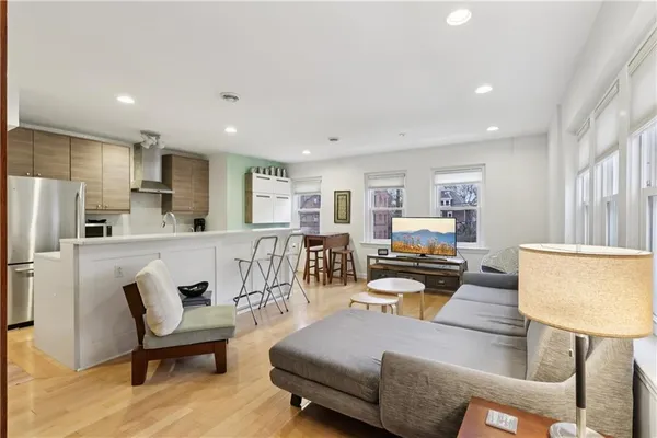 a living room with furniture and a dining table with kitchen view