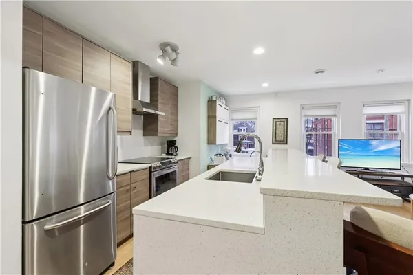 a kitchen with stainless steel appliances a refrigerator sink and stove