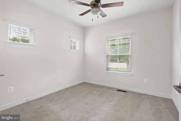 an empty room with a window and a ceiling fan